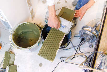 smear the tile repair in the house with a solution. Selective focus. white.