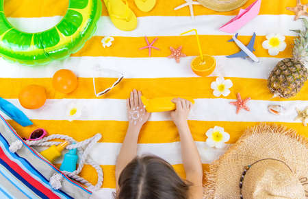 A child girl smears sunscreen on her skin. Selective focus. Kid.の写真素材
