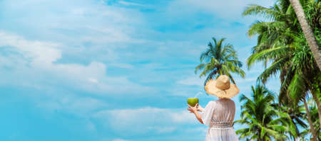 Girl on the beach drinks coconut. Selective focus. nature.の写真素材