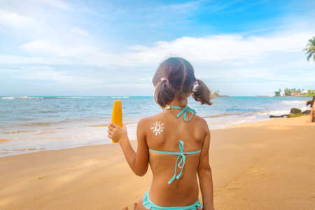 Child on the beach with sunscreen on his back. Selective focus. Travel.