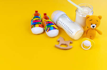 Baby milk and accessories on a yellow background. Selective focus. food.