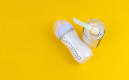 Baby milk and accessories on a yellow background. Selective focus. food.の写真素材