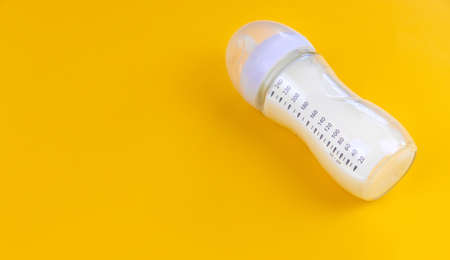 Baby milk and accessories on a yellow background. Selective focus. food.の写真素材