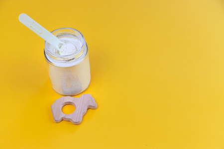 Baby milk and accessories on a yellow background. Selective focus. food.の写真素材