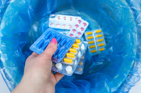 Throw away the tablets in the trash bin. Selective focus. medicine.
