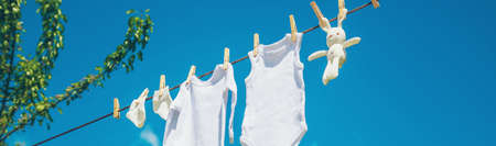 White baby clothes dry on a rope. Selective focus. nature.の写真素材