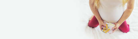 A pregnant woman holds many pills in her hands. Selective Focus. people.の写真素材