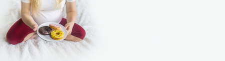 A pregnant woman eats sweet donuts. Selective Focus. Food.の写真素材