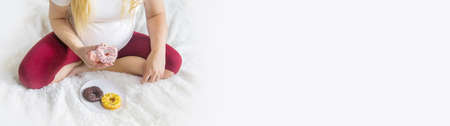 A pregnant woman eats sweet donuts. Selective Focus. Food.の写真素材