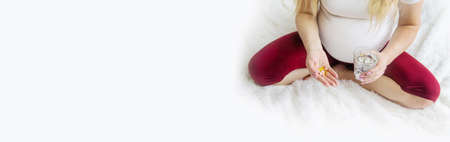 A pregnant woman drinks vitamins. Selective Focus. people.の写真素材