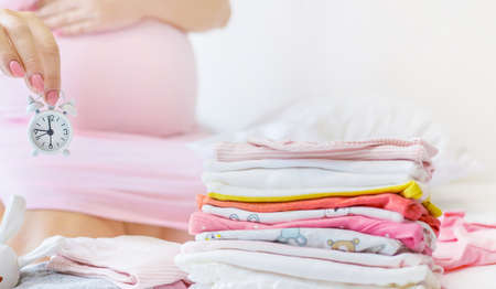 Pregnant woman with an alarm clock. Selective focus. people.