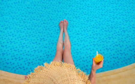 Cocktail in the hands of a girl at the pool. Selective focus. People.の写真素材
