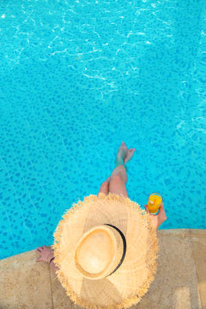 Cocktail in the hands of a girl at the pool. Selective focus. People.の写真素材