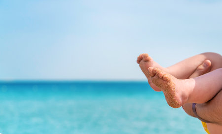 Baby feet on the background of the sea. Selective focus. People.の写真素材