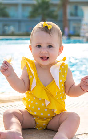 Baby near the pool is molded with water. Selective focus. People.の写真素材
