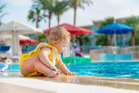 Baby near the pool is molded with water. Selective focus. People.の写真素材