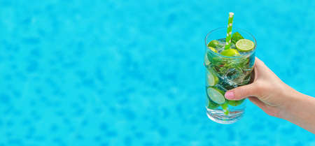 Women with cocktail near the pool. Selective focus. mojito.