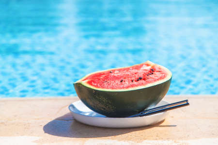 Watermelon near the pool on a plate. Selective focus. Food.の写真素材