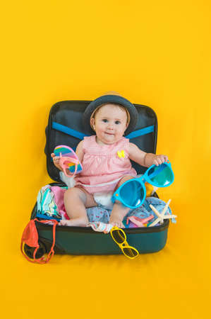 Baby and suitcase with things, luggage travel concept. Going on vacation at sea. Selective focus....
