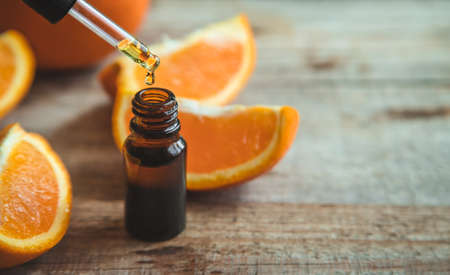 Orange essential oil in a small bottle. Selective focus. Food.の写真素材