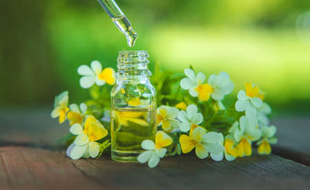 Violet essential oil in a small bottle. Selective focus. Nature.の写真素材