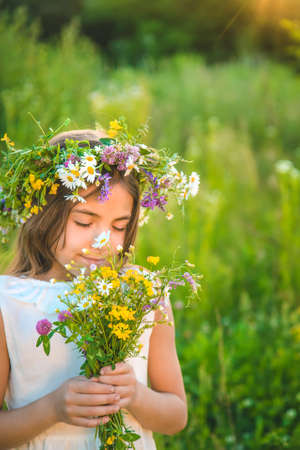 Child girl with wildflowers in summer. Selective focus. Nature.の写真素材