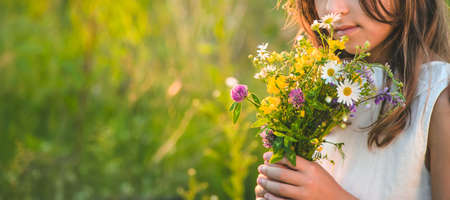 Child girl with wildflowers in summer. Selective focus. Nature.の写真素材
