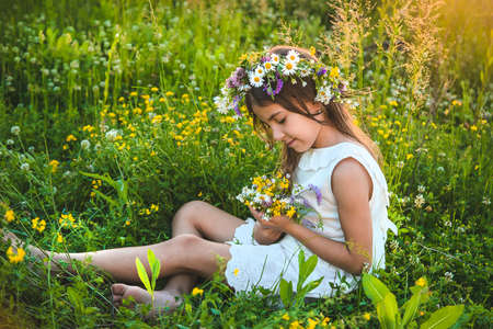 Child girl with wildflowers in summer. Selective focus. Nature.の写真素材