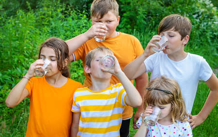Children drink water outside together. Selective focus. Kids.の写真素材