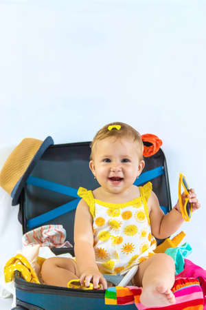 Baby is sitting in a suitcase, getting ready for a travel. Selective focus. Child.の写真素材