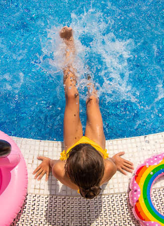Child Splashes water in the pool. Selective focus. Kid.