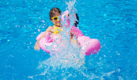 The child swims with a circle in the pool. Selective focus. Kid.
