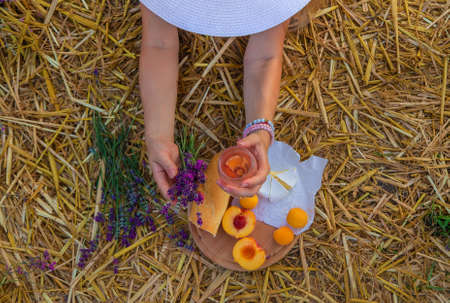 A woman holds wine in glasses. Picnic in the lavender field. Selective focus. nature.の写真素材