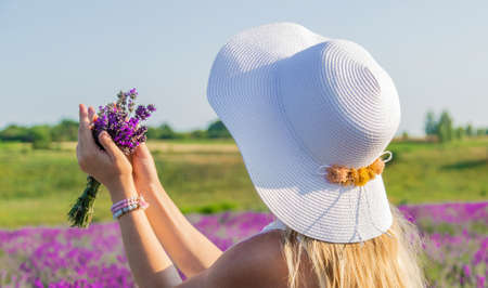 Woman with hat in lavender field. Selective focus. Nature.の写真素材