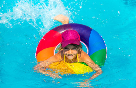 The child swims in the pool in a circle. Selective focus. Kid.の写真素材
