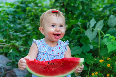 Baby eats watermelon in summer. Selective focus. Food.