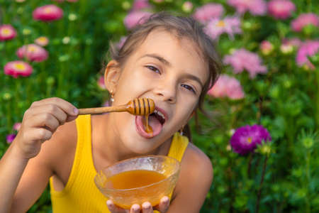 The child eats flower honey. Selective focus. Nature.の写真素材