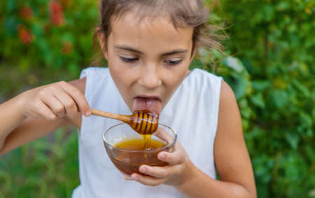 The child eats flower honey. Selective focus. Nature.の写真素材