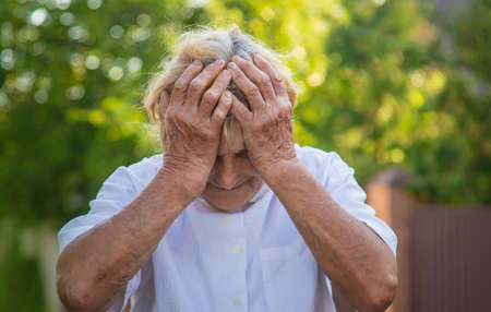 The old woman grandmother has a headache. Selective focus. Nature.の写真素材