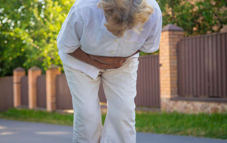 The old woman grandmother has a stomach ache. Selective focus. Nature.
