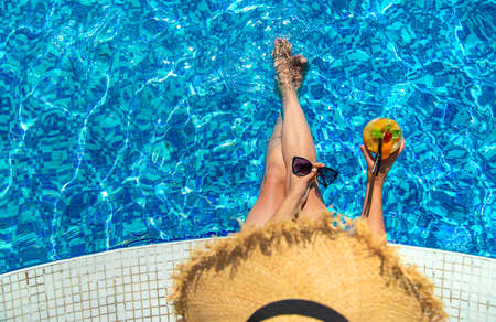 Woman with cocktail near the pool. Selective focus. Drink.
