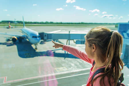 A child at the airport looks at the plane. Selective focus. Kid.の写真素材