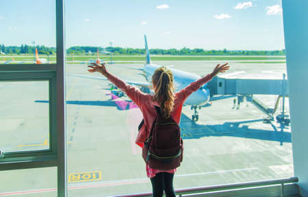 A child at the airport looks at the plane. Selective focus. Kid.の写真素材