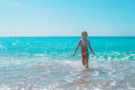 The child runs along the beach of the sea. Selective focus. Kid,の写真素材