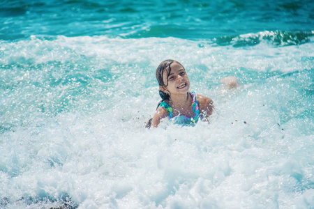 The child swims in the sea on the waves. Selective focus. Kid.