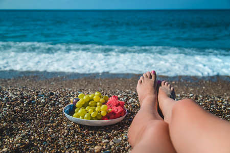 A woman at the sea eats fruit. Selective focus. Nature.の写真素材