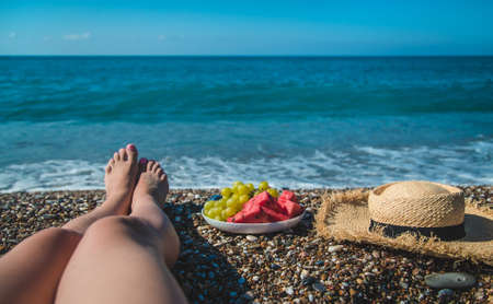 A woman at the sea eats fruit. Selective focus. Nature.の写真素材