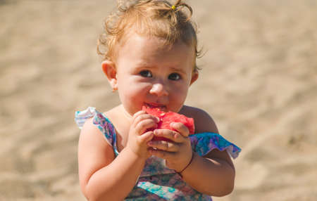 The child eats fruit by the sea. Selective focus. Kid.の写真素材