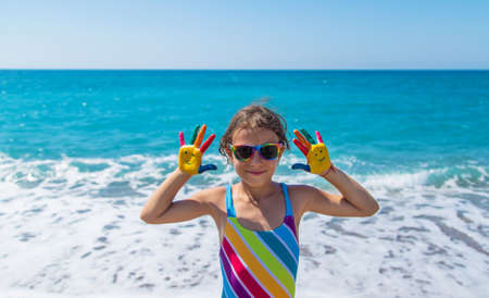 Child hands painted with paints on the sea. Selective focus. Kid.の写真素材