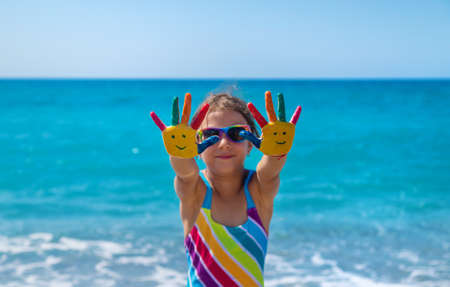 Child hands painted with paints on the sea. Selective focus. Kid.の写真素材